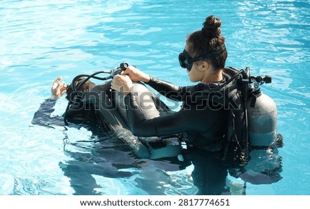 Dive instructor checking novice the diving equipment before diving