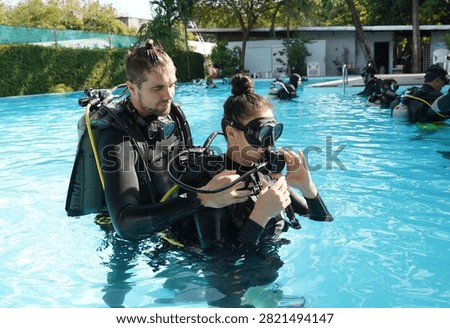 Dive instructor checking novice the diving equipment before diving