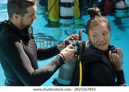 Dive instructor checking novice the diving equipment before diving