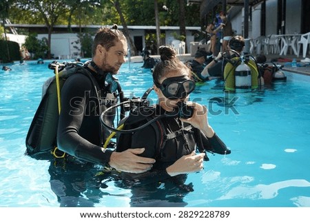Dive instructor checking novice the diving equipment before diving