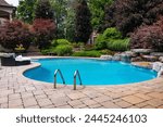 Dive into luxury with this stunning photo featuring a lavish swimming pool, exquisite house, lush green backyard, and meticulously designed garden. Experience the pinnacle of opulence and tranquility.