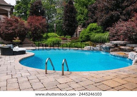Dive into luxury with this stunning photo featuring a lavish swimming pool, exquisite house, lush green backyard, and meticulously designed garden. Experience the pinnacle of opulence and tranquility.