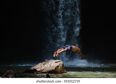 Dive From The Rock Into The Water In Front Of Jungle Waterfall