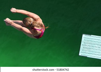 Diver Above Green Water With End Of Diving Board Visible