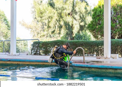 Diver Coming Out Of The Water By The Stairs Of The Pool After His Diving Class