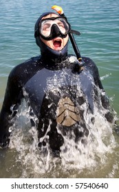 Diver In  Diving Suit With Splashes Of Jumping Out Of  Water And Gasping For Air