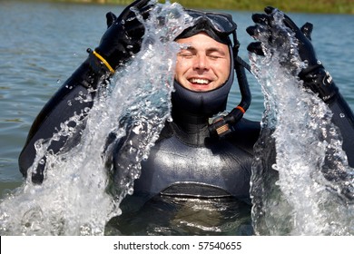 Diver In  Diving Suit With Splashes Of Jumping Out Of  Water And Gasping For Air