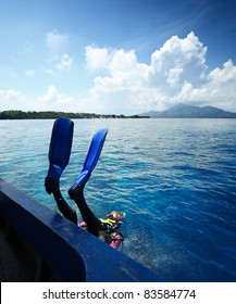 Diver Doing Back Flip Into Blue Transparent Sea From A Boat's Board