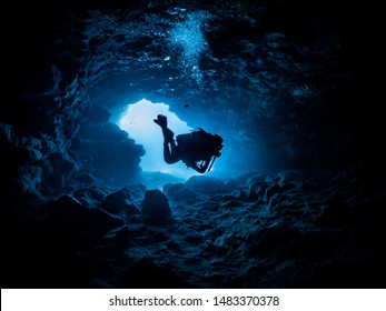 diver hovering inside a cave - Powered by Shutterstock