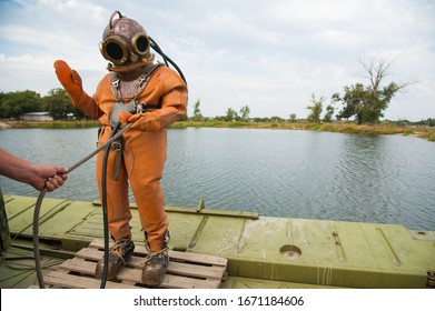 Diver Immerses In A Copper Old Vintage Deep Sea Diving Suit