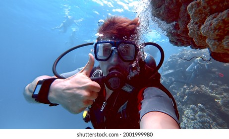 the diver looks at the camera and gives a thumbs up - Shutterstock ID 2001999980