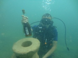 Diver In The Muddy Water. Statue In An Ancient Sunken City. Bottle Of Brandy Or Rum. Historical Public Museum.