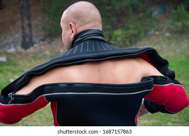 Diver Puts On A Wetsuit. Close Up Of Diver In Wet Suit Prepares For The Dive, Checks And Puts On The Equipment.