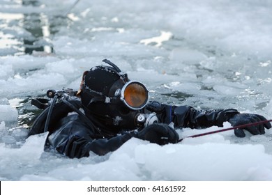 Diver rising on the surface between the ice