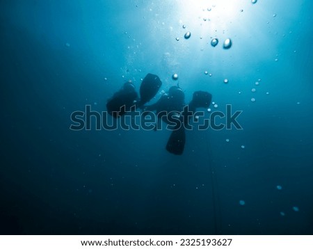 Diver silhouette and bubbles scuba diving in deep water.