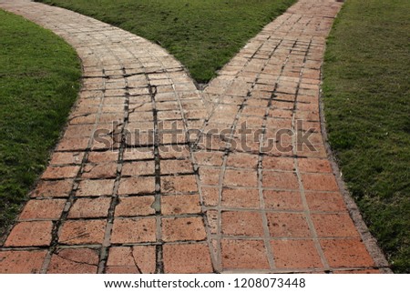 Diverging brick path on grass.