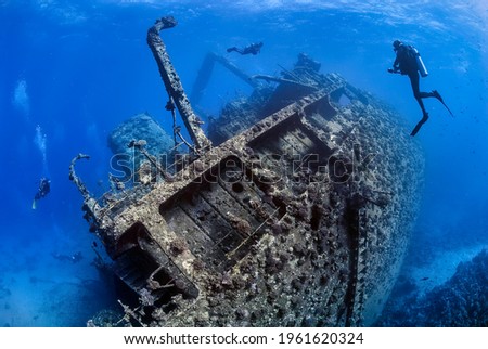 Divers exploring the outside of a shipwreck