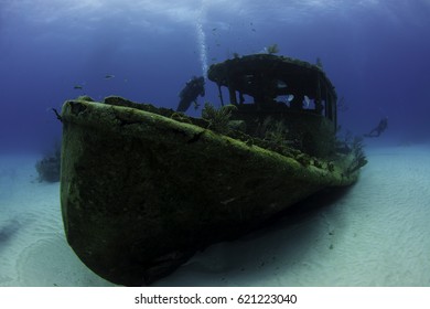 Divers Exploring The Papa Doc Wreck In The Bahamas