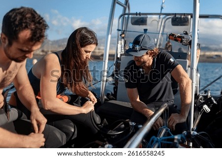 Divers preparing their scuba diving equipment on a boat, ensuring safety and teamwork before underwater exploration