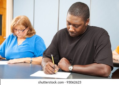 Diverse Adult Education Students Taking A Test In Class.