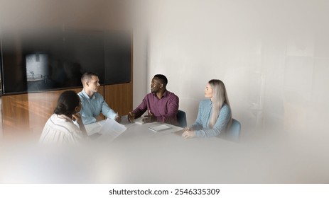 Diverse African American and Caucasian business colleagues discussing project at large table in boardroom, meeting with leader, boss for teamwork, brainstorming. Wide candid view, banner shot - Powered by Shutterstock