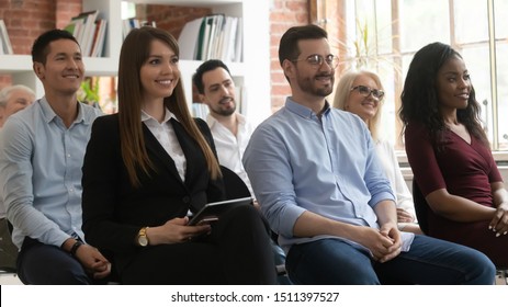 Diverse age ethnicity positive smiling entrepreneurs sitting on chairs in row taking part in seminar listening speaker enjoy speech, conference activity, business training for corporate staff concept - Powered by Shutterstock