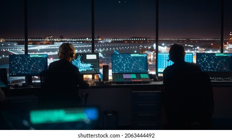 Diverse Air Traffic Control Team Working in a Modern Airport Tower at Night. Office Room is Full of Desktop Computer Displays with Navigation Screens, Airplane Flight Radar Data for Controllers.