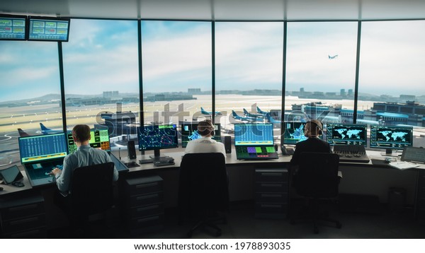 Diverse Air\
Traffic Control Team Working in a Modern Airport Tower. Office Room\
is Full of Desktop Computer Displays with Navigation Screens,\
Airplane Flight Radar Data for\
Controllers.