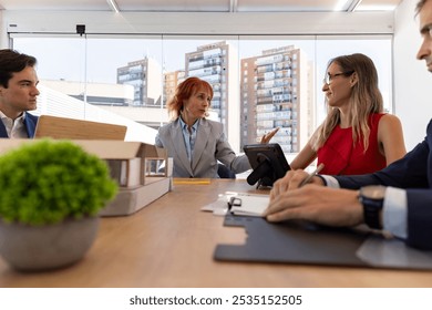 Diverse architects collaborate in a busy office, strategizing for success with laptops, blueprints, and a city view - Powered by Shutterstock