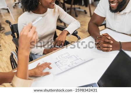 Diverse architects examining blueprints in a modern coworking space, focusing on accessibility and inclusive design