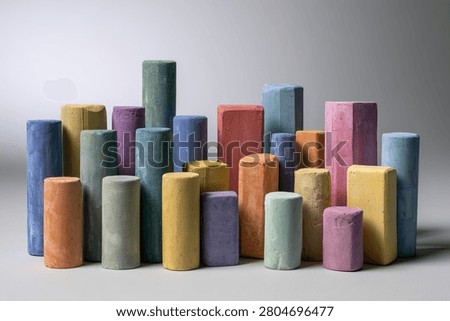 A diverse assortment of cylindrical and hexagonal chalk pastels in various hues, neatly organized for artistic creation.
