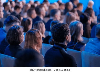 Diverse audience of professionals intently listens to a speaker at a conference event, capturing the essence of engagement and learning in a corporate environment. - Powered by Shutterstock