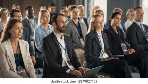 Diverse Biopharma Entrepreneurs Sitting In Crowd At International Medical Summit, Using Laptops, Tablets To Take Notes. Male And Female Industry Leaders Listening To Presentation About Biotechnology. - Powered by Shutterstock