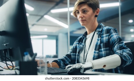 Diverse Body Positive Office: Portrait of Motivated Woman with Disability Using Prosthetic Arm to Work on Computer. Beautiful Professional with Thought Controlled Body Powered Myoelectric Bionic Hand