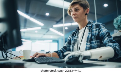 Diverse Body Positive Office: Portrait Of Motivated Woman With Disability Using Prosthetic Arm To Work On Computer. Brave Professional With Futuristic Thought Controlled Myoelectric Bionic Hand