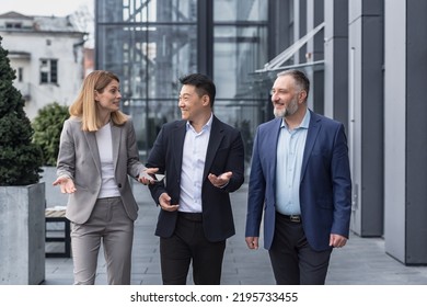 Diverse Business Group, Three Male And Female Workers Walking And Chatting Discussing Plans, Outside Office Building