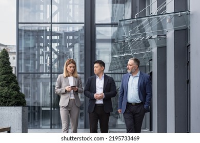 Diverse Business Group, Three Male And Female Workers Walking And Chatting Discussing Plans, Outside Office Building