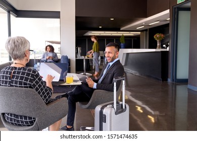 Diverse Business Partners Sitting In Modern Airport Lounge With