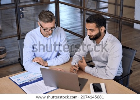 Similar – two men and a woman sit in front of a building on giant letters ,model and photograph each other with their smartphones