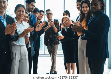 Diverse business people clapping and applause at new manager while standing. A group of business team in office uniform congratulating on colleague promotion. Office bright hall. Intellectual. - Powered by Shutterstock