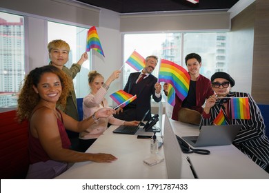 Diverse Business People (man, Woman, Gay, Transgender, Lesbian, Asian, Caucasian, African American, Lgbtq) With Rainbow Flag On Hand In Business Office Working Together As Teamwork Selective Focused