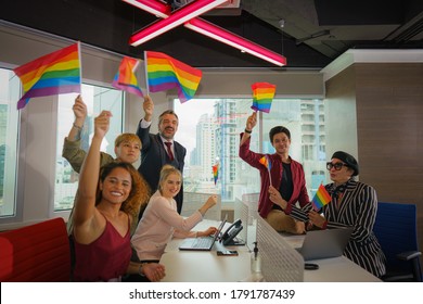 Diverse Business People (man, Woman, Gay, Transgender, Lesbian, Asian, Caucasian, African American, Lgbtq) With Rainbow Flag On Hand In Business Office Working Together As Teamwork Selective Focused