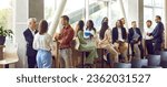 Diverse business professionals communicating at a conference, seminar or other educational event. Young and mature multiethnic people meeting in the office and having discussions. Banner background