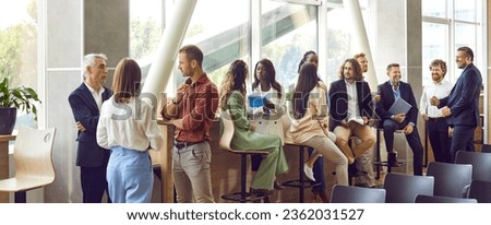 Diverse business professionals communicating at a conference, seminar or other educational event. Young and mature multiethnic people meeting in the office and having discussions. Banner background Foto d'archivio © 