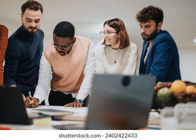 Diverse business team analyzing reports, discussing strategies for growth. Colleagues working extra hours to meet project deadline. Creative brainstorming in modern office. - Powered by Shutterstock