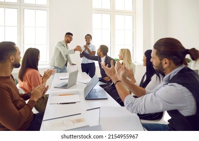 Diverse Business Team Celebrating Success In Office Meeting. Happy Black Man Exchanges Bro Handshake With Coworker While Mixed Race Multi Ethnic Teammates Are Applauding. Teamwork And Success Concept