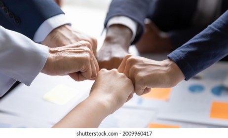 Diverse Business Team Making Group Fist Bump. Employees Engaged In Teamwork, Keeping Community Spirit, Expressing Solidarity, Trust, Unity, Friendship. Close Up Of Multiethnic Hands