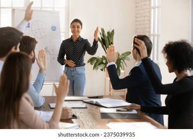 Diverse business team and presenter voting for new project plan, best marketing decision on presentation meeting. Audience and speaker raising hands, making group choice for cooperation - Powered by Shutterstock