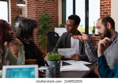 Diverse businesspeople discussing marketing turnover planning business collaboration during corporate meeting in startup office. Multi-ethnic team brainstorming ideas working at management strategy - Shutterstock ID 2140922035
