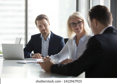 Diverse businesspeople negotiate at office meeting discussing startup project with clients, company managers have conversation with business partner, consider collaboration. Partnership concept